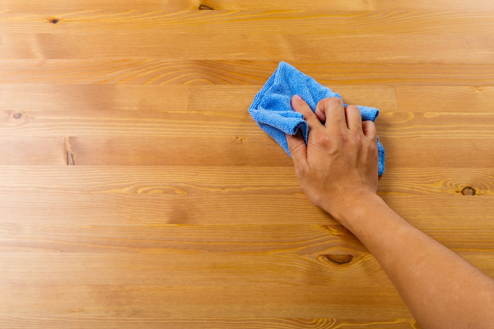 House cleaner cleaning table by hand